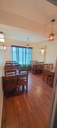 a dining room with wooden tables and wooden chairs at Shree Niwas in Darjeeling