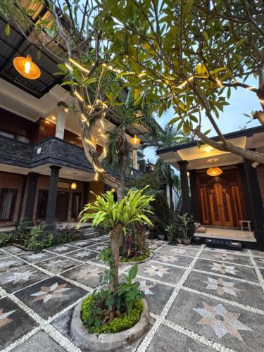 a courtyard with a tree in front of a building at Murni’s House in Lovina