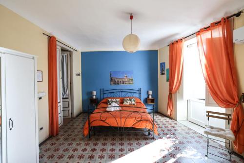 a bedroom with an orange bed and a blue wall at Antica Dimora in Palermo