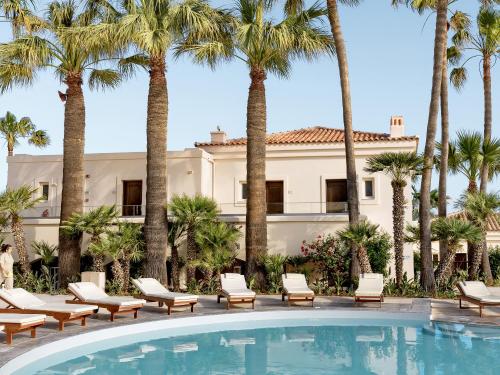 a resort with palm trees and a pool at Grecotel Marine Palace & Aqua Park in Panormos Rethymno