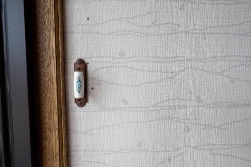 a doorhandle to a glass door with a view of a mountain at 中町ハウス in Biei