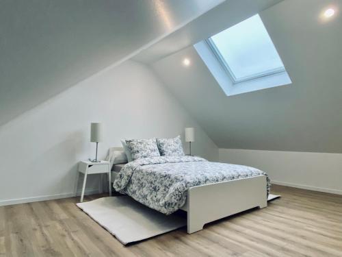 - une chambre blanche avec un lit et une lucarne dans l'établissement Spacious apartment near Disneyland & GDC, à Annet-sur-Marne
