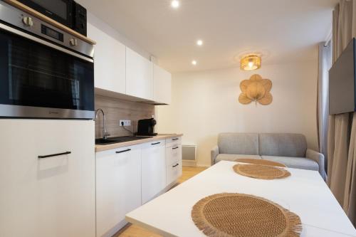 une petite cuisine avec une table et un canapé dans l'établissement Île aux moines - T2 - centre ville - wifi, à Vannes