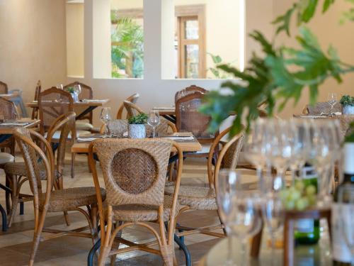 a dining room with tables and chairs with glasses at Grecotel Marine Palace & Aqua Park in Panormos Rethymno