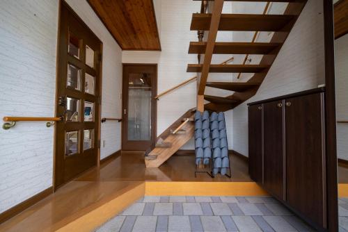 a hallway with a wooden staircase in a house at 中町ハウス in Biei