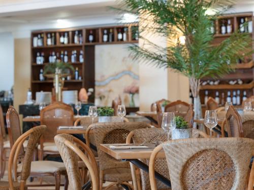 a restaurant with tables and chairs with wine glasses at Grecotel Marine Palace & Aqua Park in Panormos Rethymno