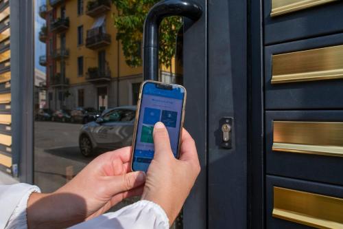 a person holding a cell phone in front of a door at Borgo Trento Home, vicinissimo ospedale Borgo Trento e centro storico in Verona