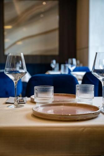 a table with a plate and wine glasses on it at Hotel Atrium in Kraków