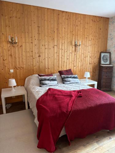 une chambre avec un lit avec une couverture rouge dessus dans l'établissement Les racines et les cimes, à La Lechere