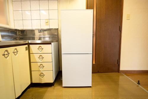 a kitchen with a white refrigerator in a kitchen at 中町ハウス in Biei