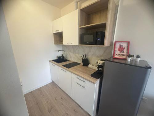 a small kitchen with white cabinets and a refrigerator at Campari Home - 15 min da Venezia in Venice