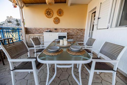 Biały stół i krzesła na patio w obiekcie Aperanto Galazio Apartment w mieście Archangelos
