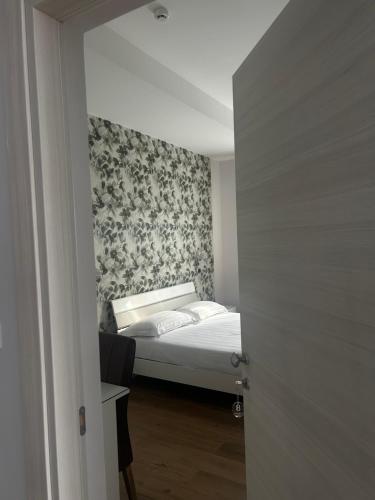 a small bedroom with a bed with a wall at Hotel Villa Ruggiero in Brusciano