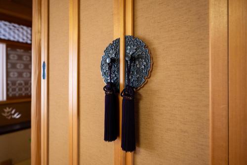a doorhandle with a clock on a wooden door at 中町ハウス in Biei