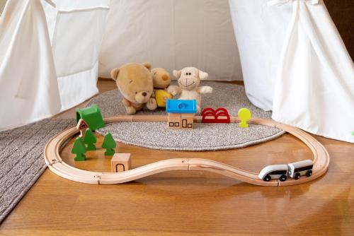 a toy train with two stuffed animals on a floor at 中町ハウス in Biei