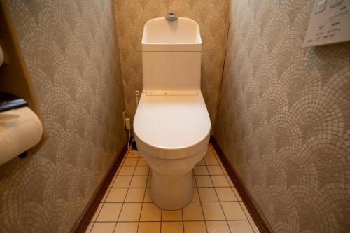 a bathroom with a white toilet in a stall at 中町ハウス in Biei