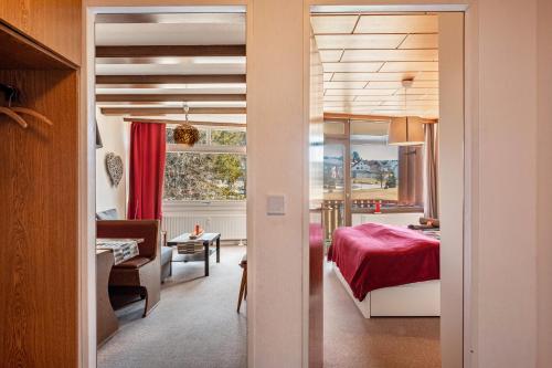 - une chambre avec un lit rouge et un salon dans l'établissement Ferienwohnung Schluchseetraum, à Schluchsee