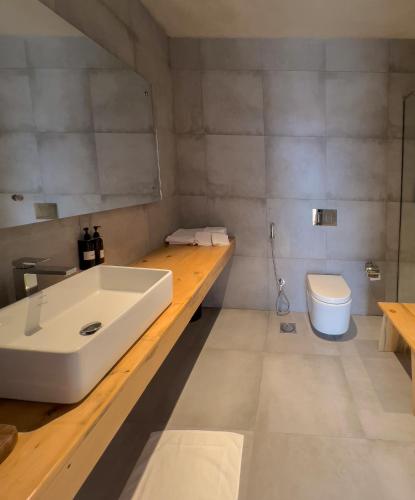 a bathroom with a white sink and a toilet at The Rihla Hunza - Managed By Luxus in Hunza
