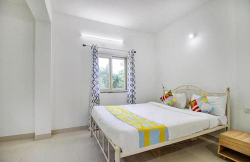 a bed in a white room with a window at Exotic star 1 BHK 2BHK Apartment in Socorro
