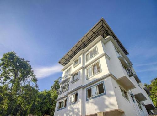 a white building with a roof on top of it at Exotic star 1 BHK 2BHK Apartment in Socorro