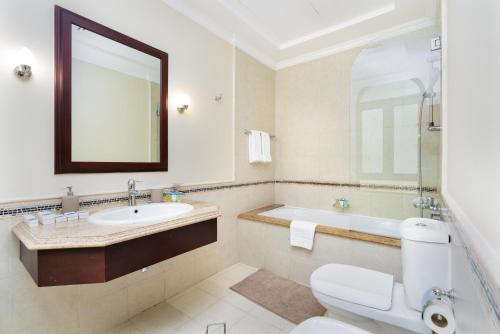 a bathroom with a sink and a toilet and a tub at Samaya Holiday Homes - Luxury Villa Pool - Beach Access & Fishing Zone in Dubai