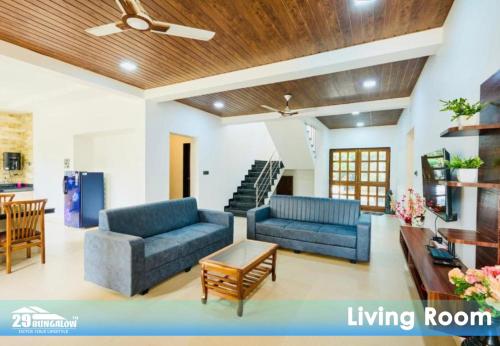 a living room with two blue couches and a table at Rooms At Harbour View Villa in Matralipāda