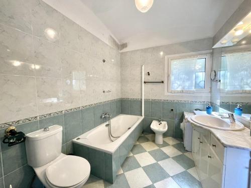 a bathroom with a toilet and a tub and a sink at casa 7 pins in Begur