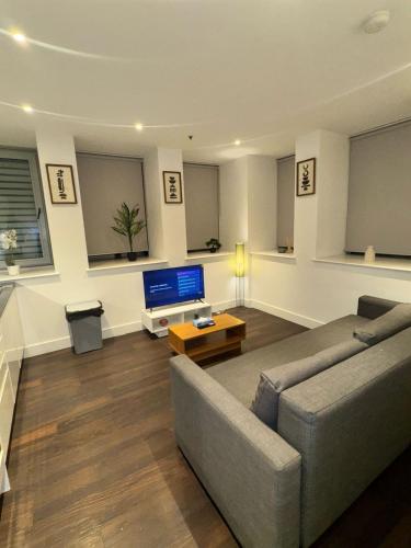 a living room with a couch and a tv at Sleep 9 20 mins from London Waterloo BP172 in London