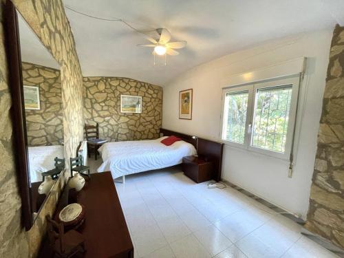 a bedroom with a bed and a stone wall at casa 7 pins in Begur