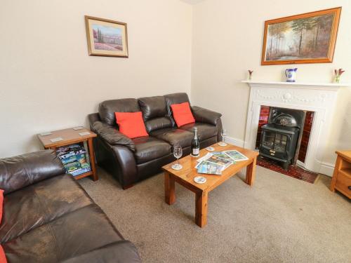 a living room with a leather couch and a coffee table at South View in Leyburn