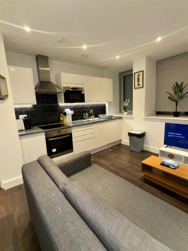 a living room with a couch and a kitchen at Sleep 9 20 mins from London Waterloo BP172 in London