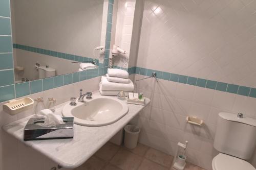 a bathroom with a sink and a mirror and a toilet at Toscana Wellness Resort in Arcidosso
