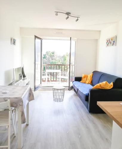 un salon avec un canapé et une table dans l'établissement Superbe F2 avec balcon vue mer - 4 personnes, à Cabourg