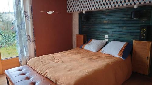 1 dormitorio con cama grande y sofá de cuero en Chez David, en Bressuire