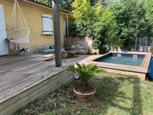 une cour arrière avec une piscine et une terrasse en bois dans l'établissement Villa Chilensis 5 min from Aix south east France with private pool, à Aix-en-Provence