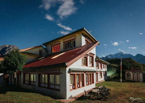 a building with a picnic table in front of it at Sherpa Panorama Hotels in Khumjung