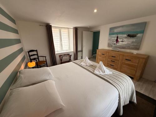 Un dormitorio con una gran cama blanca y una ventana. en Clos des Huards au milieu de la loire à vélo, en Cour-Cheverny