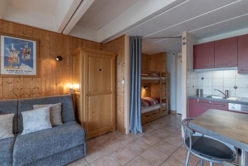 un salon avec un canapé et une cuisine dans l'établissement Appartements Flaine - 4p, à Arâches-la-Frasse