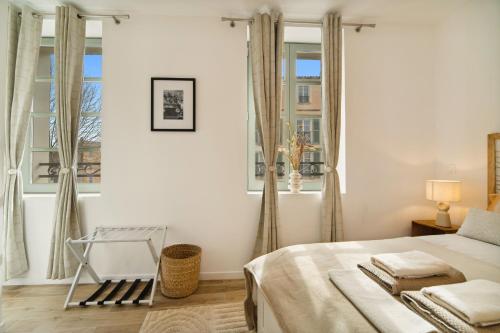 une chambre blanche avec un lit et deux fenêtres dans l'établissement Escale Tropézienne 104 Allard 2D, à Saint-Tropez