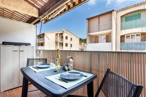 - une table avec une bouteille de vin sur le balcon dans l'établissement L'Escapade Marine, aux Lecques