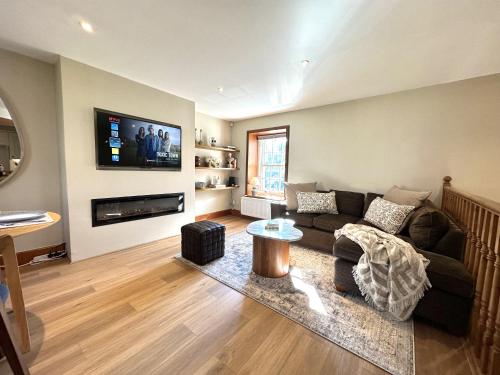 a living room with a couch and a tv on a wall at Barossa Nook, 2 Bedroom House in Perth