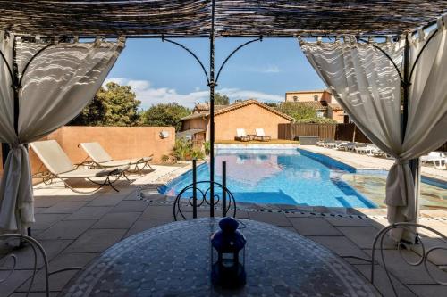 un patio avec une table et une piscine dans l'établissement La rose des vents, à Néoules