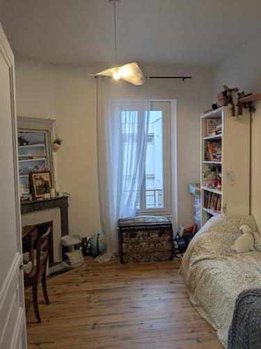 - une chambre avec un lit, une cheminée et une fenêtre dans l'établissement Grand F3 Clermont Ferrand Centre et Garage salins, à Clermont-Ferrand