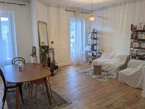 un salon avec une table et un canapé dans l'établissement Grand F3 Clermont Ferrand Centre et Garage salins, à Clermont-Ferrand