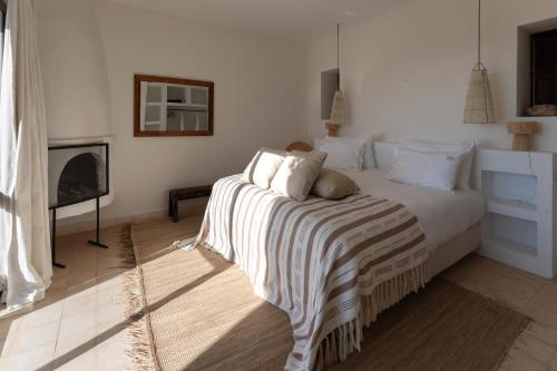 a bedroom with a bed with a striped blanket on it at La Mouette et les Dromadaires in Essaouira