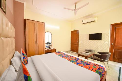 a bedroom with a bed and a desk and a television at Hotel Gracious - Civil Line in Gurgaon