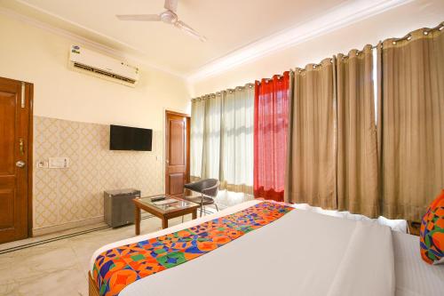 a bedroom with a bed and a desk and a television at Hotel Gracious - Civil Line in Gurgaon