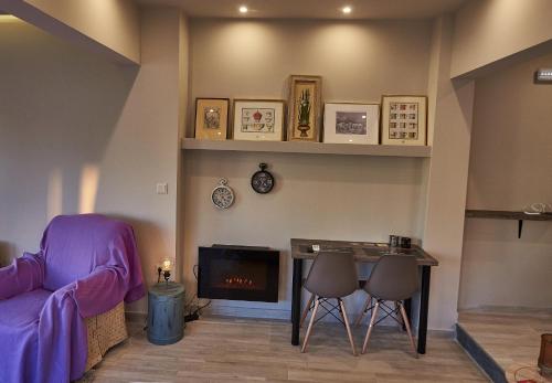 a living room with a couch and a table and a fireplace at Lycabettus View Kaniggos in Athens