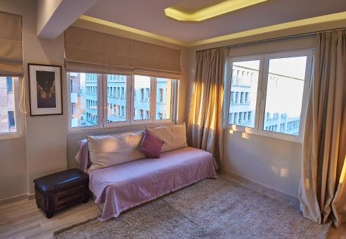 a bedroom with a bed and two windows at Lycabettus View Kaniggos in Athens