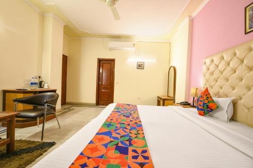 a bedroom with a bed and a desk and a chair at Hotel Gracious - Civil Line in Gurgaon